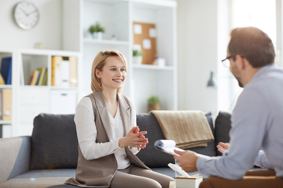 smiling woman sitting on a couch in therapy